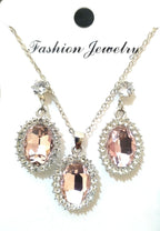 Jewelry set with rose gold pendant and matching earrings on a white background