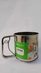 Metal mug with green label featuring the brand 'MIM' on a white background