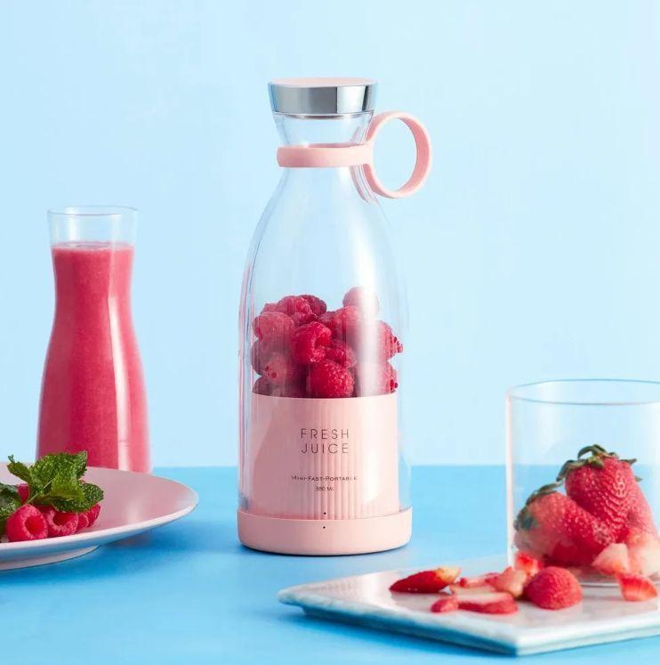 Pink glass bottle with raspberries labeled 'Fresh Juice' on a blue background