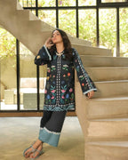 Woman in a floral embroidered outfit standing on a staircase