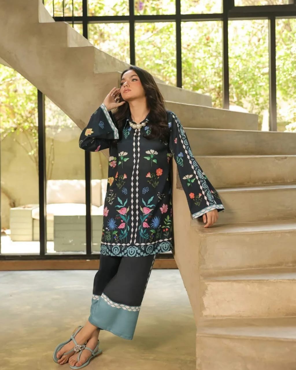 Woman in a floral embroidered outfit standing on a staircase