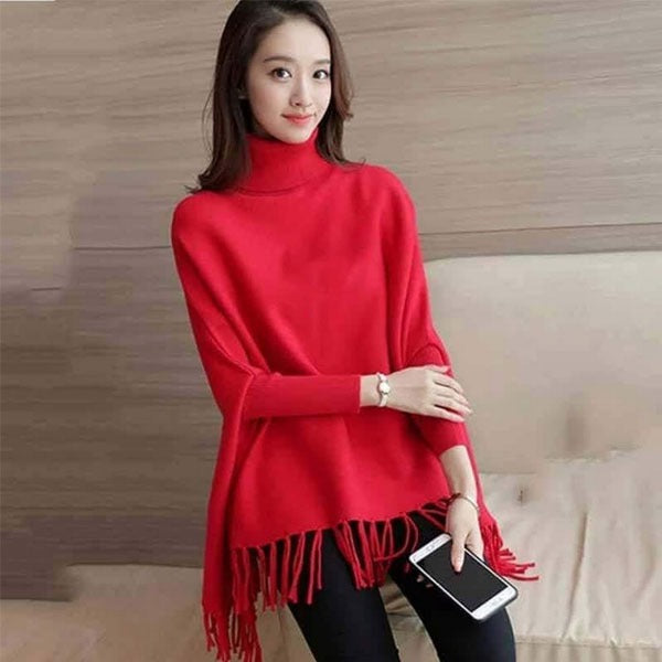 Woman wearing a red poncho with tassels indoors