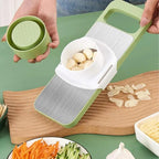 Garlic peeler with garlic on a wooden cutting board, surrounded by vegetables.
