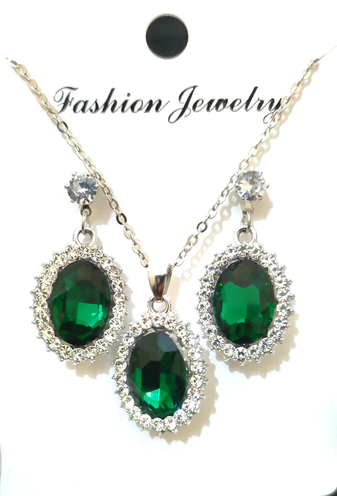 Jewelry set with green gemstones on a white background