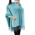 Light blue poncho with fringe details on a white background
