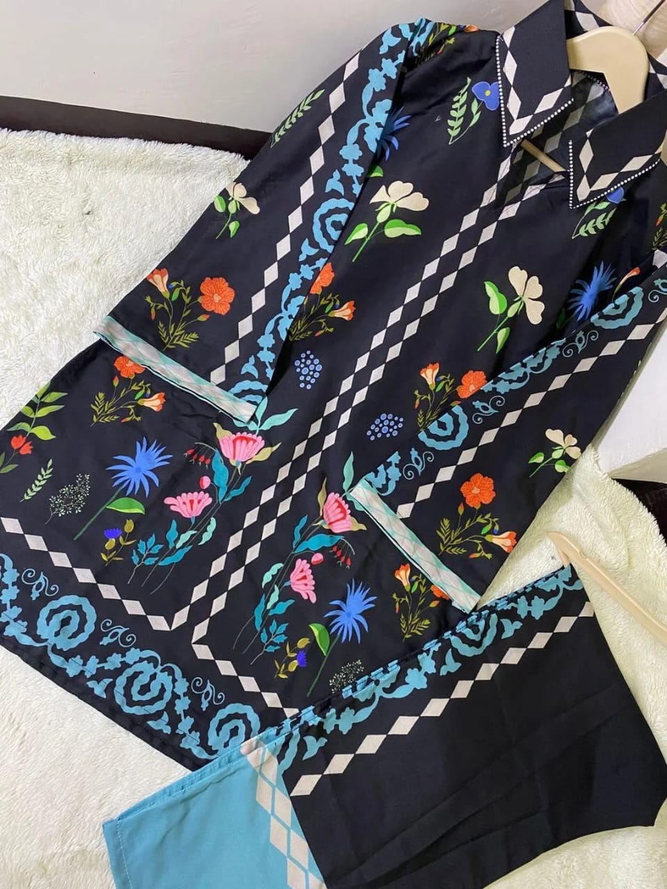Navy blue scarf with colorful floral and geometric patterns on a white surface
