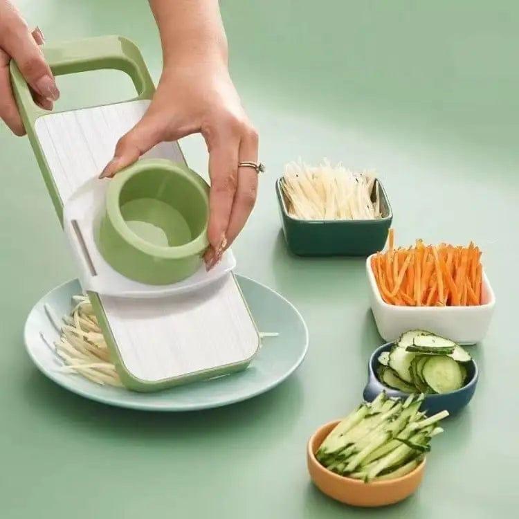 Vegetable slicer with sliced vegetables on a green background