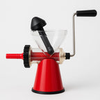Red manual coffee grinder with black accents on a white background