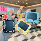 Three small electronic doodle boards with colorful frames and cartoon designs held by a person in a mall.