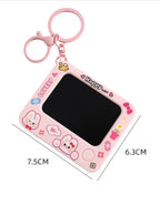 Pink cartoon-themed keychain with a small screen and measurements on a white background