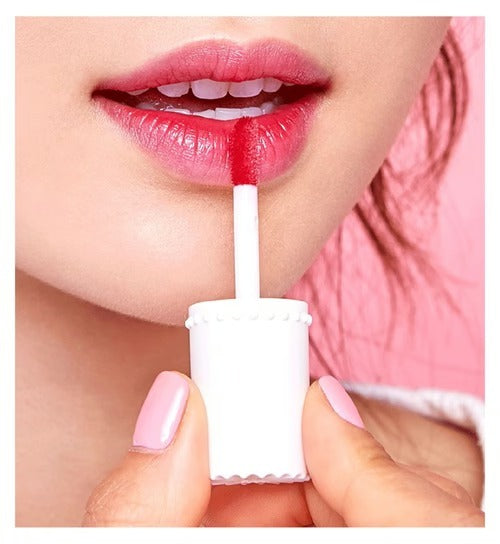 Close-up of a person applying red lipstick with a white applicator.