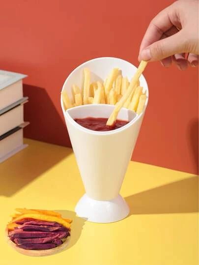 White condiment cup with compartments for fries and ketchup on a yellow surface with a red background