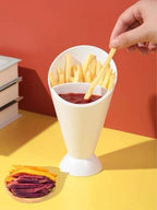 White condiment cup with compartments for fries and ketchup on a yellow surface with a red background
