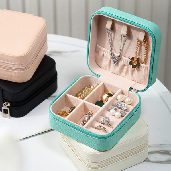 Jewelry organizer with necklaces, rings, and earrings on a light surface.