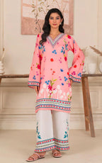 Woman wearing a pink embroidered kurta with white pants in a decorated room.