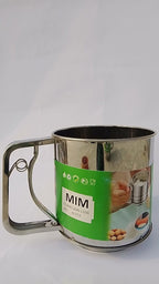 Stainless steel mug with a green label featuring the brand 'MIM' on a white background.