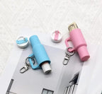 Two lip balm keychains, one blue and one pink, on a textured white surface.