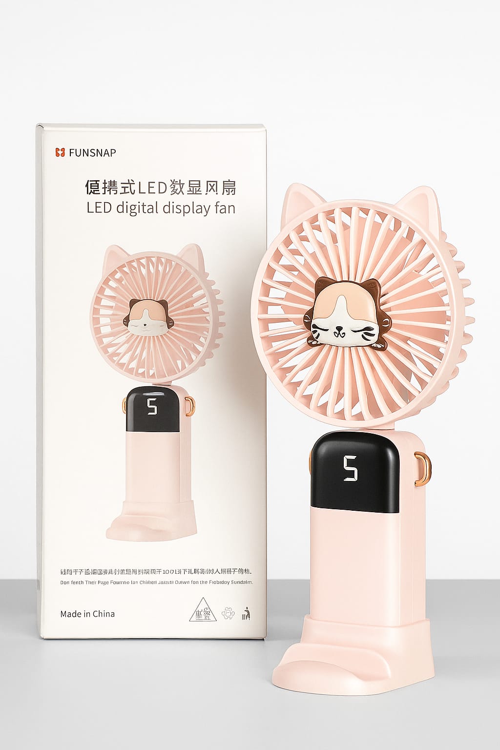 Pink handheld fan with LED digital display and packaging on a white background