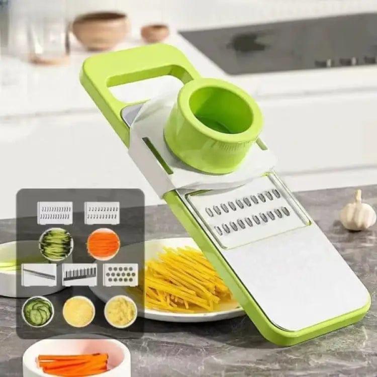 Green and white mandoline slicer with adjustable blades on a kitchen counter.