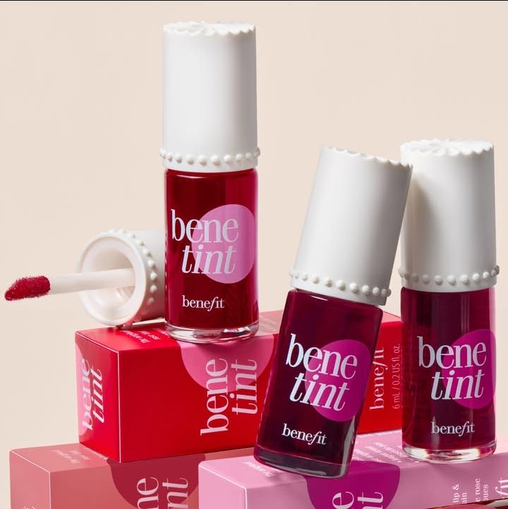 Benefit benetint lip tint bottles with applicator on a beige background