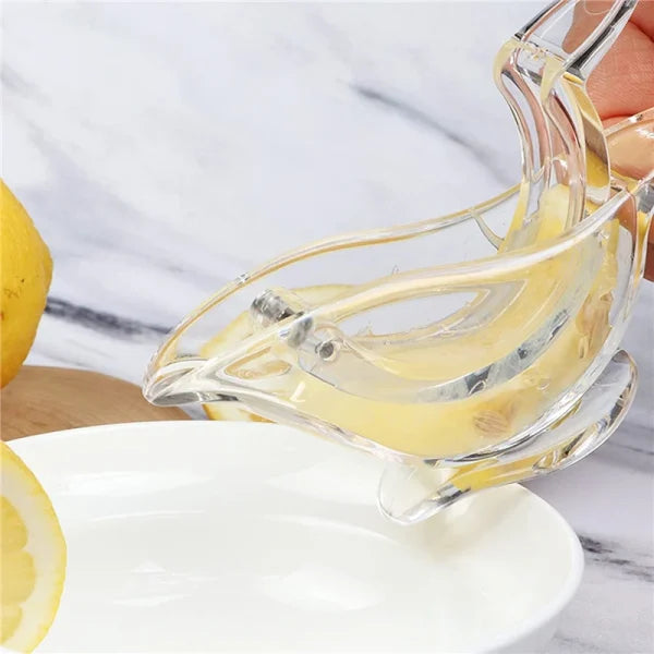 Clear glass lemon squeezer with lemons on a marble surface
