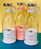 Three transparent bottles with colorful lids and 'Fresh Juice' labels on a blue and yellow gradient background.